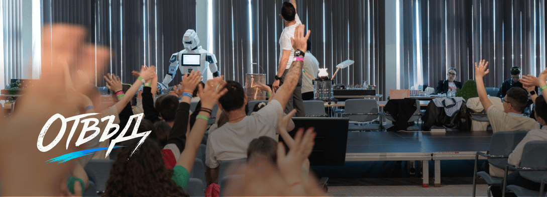 Audience with raised hands watching a humanoid robot and presenter in a modern conference room.